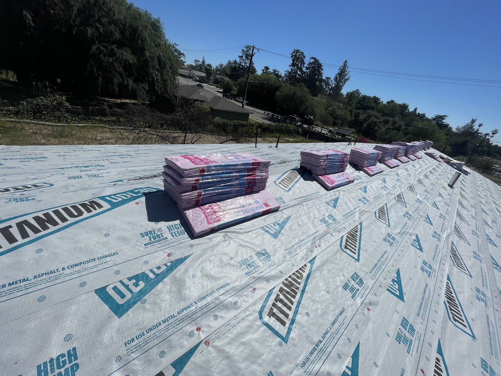 Roof covered with underlayment and bundled shingles ready for installation