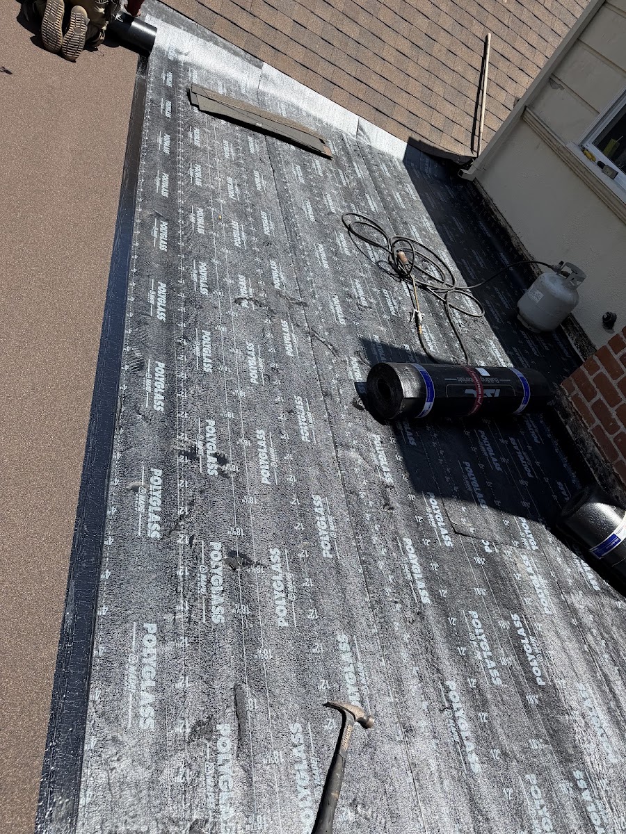 Torch-down roofing membrane installation at a low-slope transition